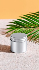 Silver Metal Tin on Beige Sand with Palm Leaf
