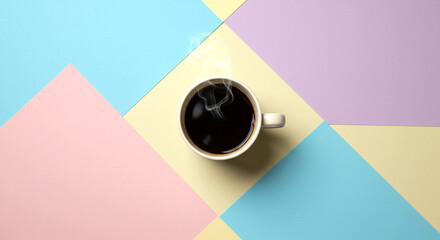 A coffee cup on a desk with paper clips and a pen