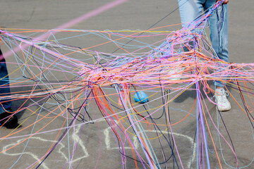 A web of multi-colored knitting threads during a group communication game