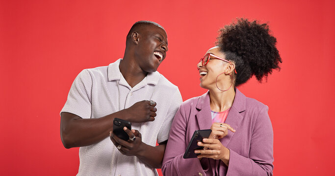 Happy couple, laughing or meme with phone in studio for social media or fashion on red background. Online post, notification or people with smile or mobile app for chat, funny joke and connection