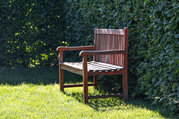 Empty wooden bench inviting relaxation in lush green garden