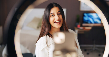 Podcast, ring light and streaming with influencer woman in home for live broadcast or recording. Face, phone and tutorial with happy content creator in apartment for instructions or recommendation