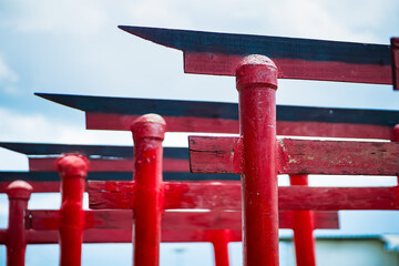 Close-up view of traditional red torii gates with a blue sky background representing Japanese...