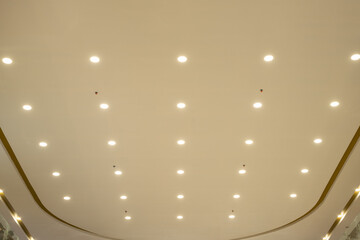 Modern ceiling with evenly spaced recessed lights and minimalist design in a commercial indoor space, photographed from directly below.