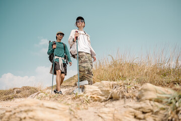 Asian couple hiking mountain trail. Hiker lifestyles activity. Hike trekking backpacker. Backpacker trekking outdoors.