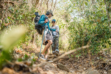 Asian couple hiking forest trail. Hiker lifestyles activity. Hike trekking backpacker. Backpacker trekking outdoors.