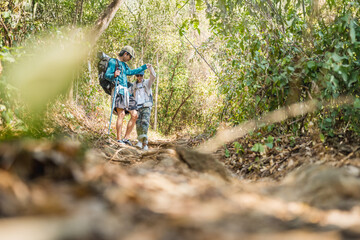 Asian couple hiking forest trail. Hiker lifestyles activity. Hike trekking backpacker. Backpacker trekking outdoors.