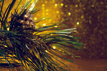 New Year decorations, Christmas tree with cones. Natural branches of pine on glowing golden...