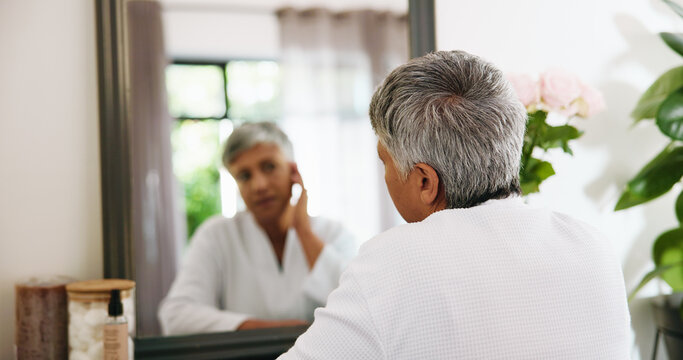 Back, mirror and senior woman with skincare, wrinkles and anti aging with wellness. Home, pensioner and elderly person with reflection, morning routine and grooming with healthy skin and cosmetics