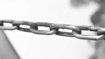 Obraz premium Close-up of a rusty metal chain. A symbol of connection, strength, aging, or an industrial concept. Black and white photo.