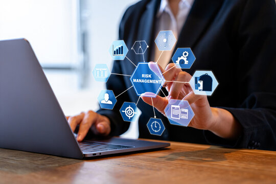 Businessperson using laptop and interacting with a risk management holographic interface