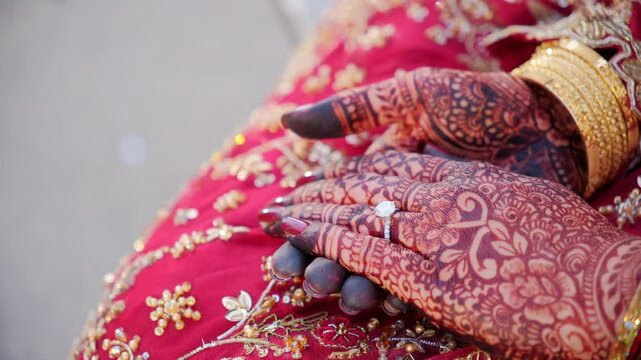 Traditional henna painting on bridal hands. Red color is the traditional Indian clothes, Elements of hindu wedding. 