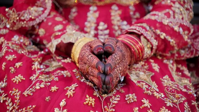 Traditional henna painting on bridal hands. Bride opens her hands. Red color is the traditional Indian clothes, Elements of hindu wedding. 