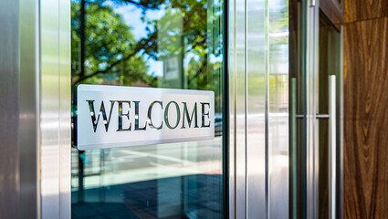 Modern glass door with a welcome sign