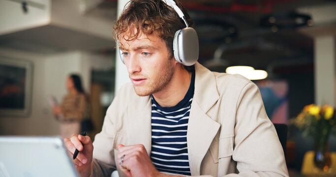 Headphones, laptop and webinar with business man in office for development or learning online. Computer, streaming and upskill video with employee listening to training course for work orientation - Powered by Adobe