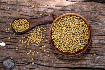 Spice coriander (Coriandrum sativum) seeds in wooden bowl and spoon on wooden background. Indian cuisine, ayurveda