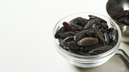 closeup pile of tonka bean in glasses bowl on white table background with copy space