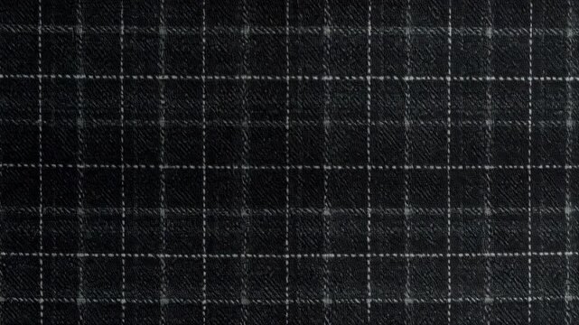 Dark gray wool suiting fabric displaying a small square checkered pattern with thin white lines forming the grid for abstract design use
