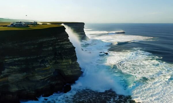 A beautiful ocean view with a cliff in the background. The water is calm and the sky is clear