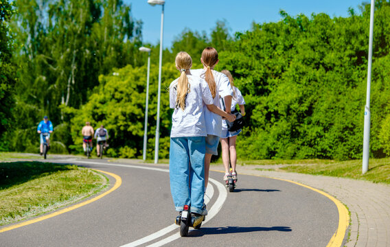 Girls rides an electric scooter in the summer Park
