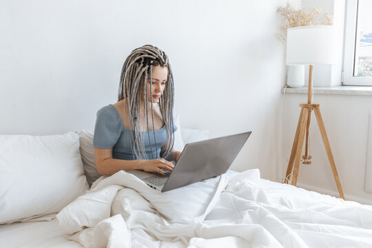 Business woman working on computer, laptop in white bed.