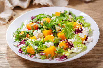 plate of salad with baked pumpkin, greens and cream cheese