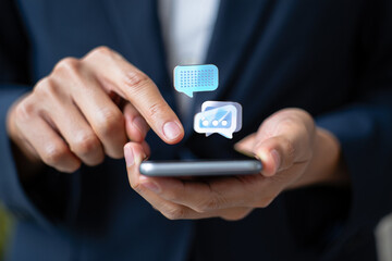 Businessperson using smartphone with digital chat message icons