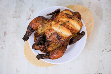 Roasted chicken whole on white plate	
