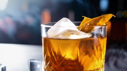 Elegant crystal glass filled with amber cocktail, ice cubes, citrus zest and rising smoke on sleek surface with dark backdrop. - Powered by Adobe
