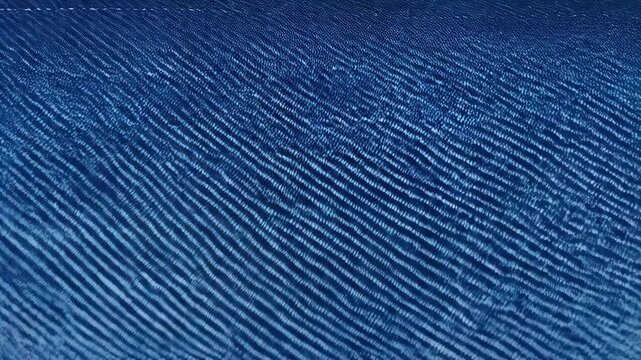 Close-up of deep blue cotton fabric with subtle texture, revealing tight weave and consistent color with a linear pattern.