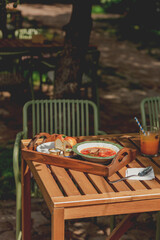 Delicious Ukrainian borscht with pear served on a wooden tray in a street cafe.