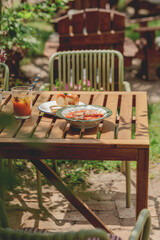 Delicious Ukrainian borscht with pear, bread and drinks served on a wooden table.