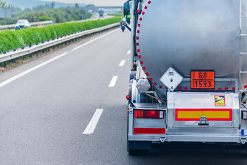 Rear view of a hazardous materials tanker truck, featuring the orange panel with hazard...