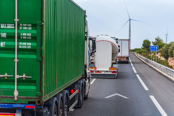 Several trucks in a row overtaking on a highway, merging into the left lane.