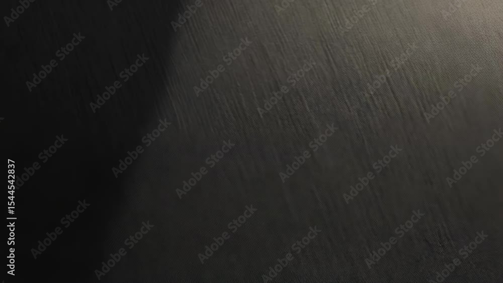 Poster close-up of finely textured dark grey fabric, showing subtle diagonal ridges and a shadowed edge in 