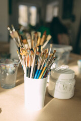 The artist's working studio. Plaster base, stand, brushes in the stand. The artist's concept. Close-up.