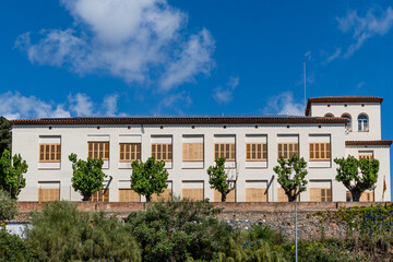 Fototapeta premium Montgat, Spain-June 21, 2025. Les mallorquines civic center building with blue sky and clouds in Montgat, spain