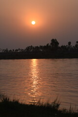 Sindh Of Autumn River Landscape  Or asia Part Of Pakista At Sunset. Sun Shine Over Blue Water Lake Or River At Sunrise. Nature At Sunny Morning. Woods With Orange Foliage On Riverside