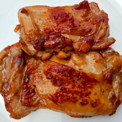 Savory Delight: a close-up shot of perfectly cooked chicken thigh pieces, their golden-brown skin glistening enticingly.