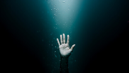 Hand reaching up from dark water bubbles