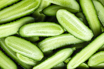Fresh green organic sliced cucumbers background, top view with copy space