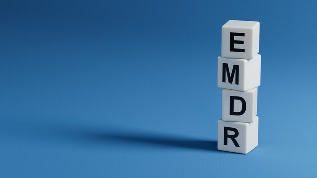 The text EMDR word Eye Movement Desensitization is written on notepad . Medical concept.close up of wooden elements,Business Concept.3D rendering on blue background.