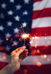 Sparklers in hand  on an American Flag background. Independence day United States. Celebration 4th...