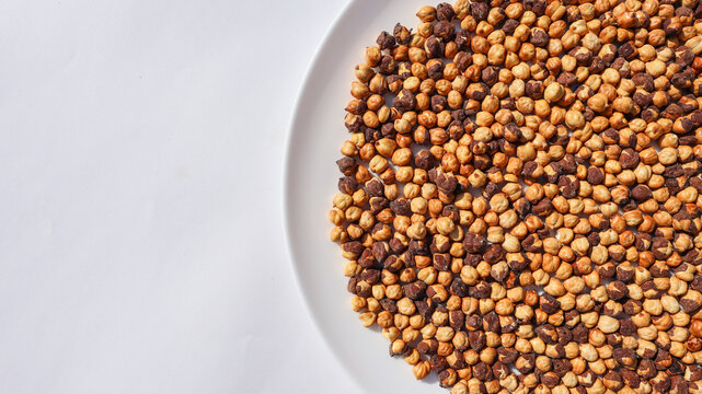 Top view of Roasted Chickpeas or bengal gram or chana with brown husk on white background.