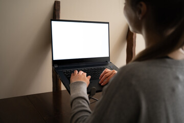 Rear view of unrecognizable woman typing on laptop at adjustable laptop stand for desk for good...