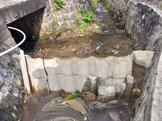 Small Stream with Makeshift Dam and Concrete Banks