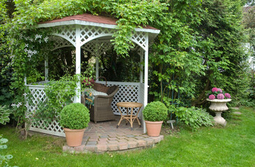 Kiosque en bois blanc,Table et fauteuil en rotin, Buis en pot, Hortensia en pot, Jardin Iréne et Heinz Auer. Gaienhofen, Lac de Constance, Allemagne
