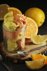 Lemon and orangeg ice cream scoops in glass jar	