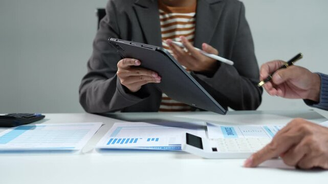Business consultants discuss tax, merger strategy and restructuring in modern office.