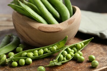 Fresh ripe green peas on wooden table, closeup